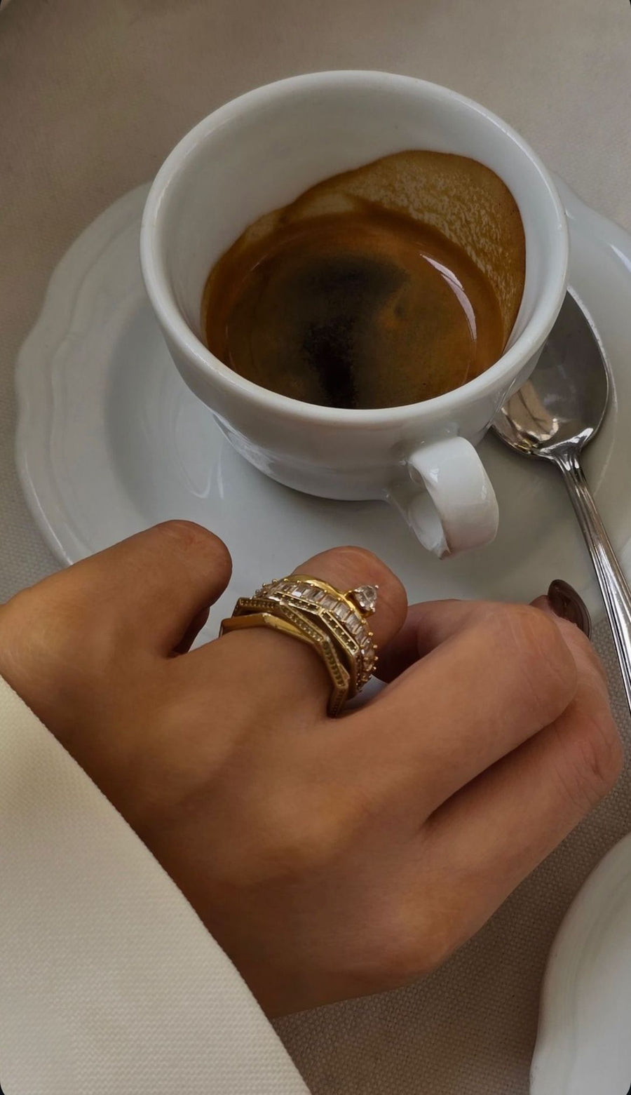 Cliente con anillo dorado de varias bandas con circonitas de Vivante Madrid junto a un café