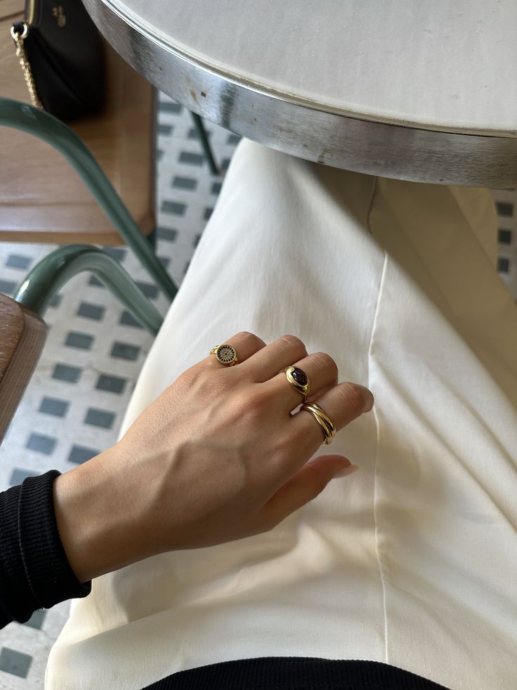 Cliente con anillos dorados de Vivante Madrid, uno con piedra oscura, en una terraza