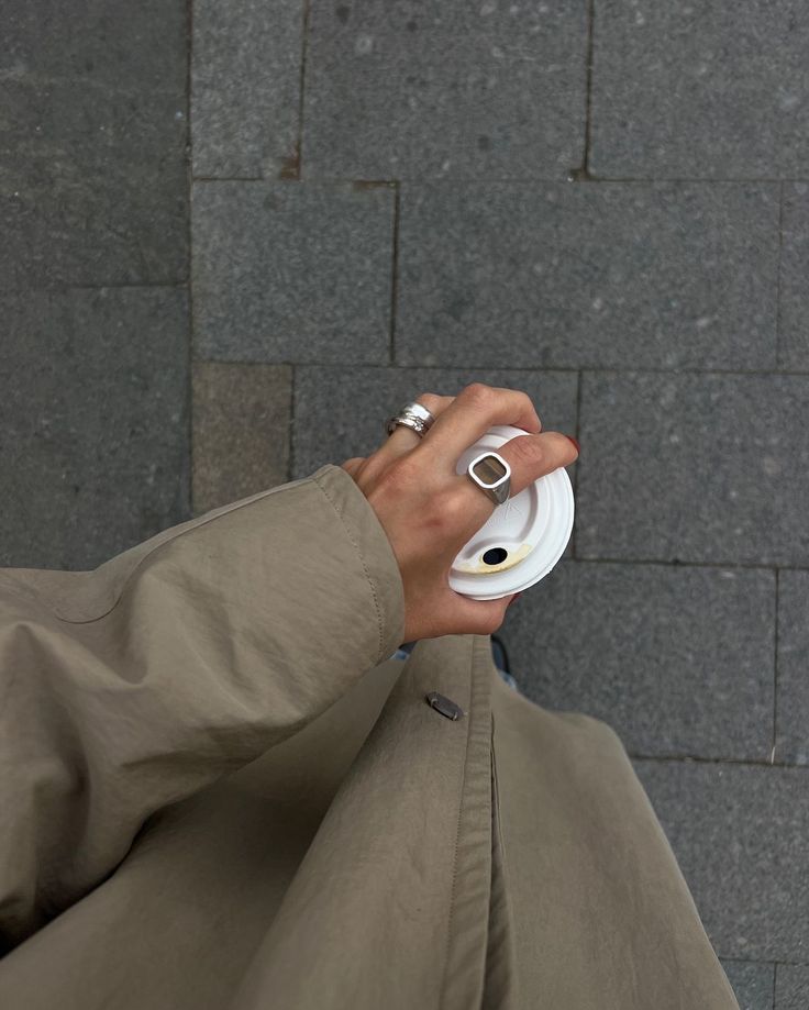 Cliente con anillos plateados de Vivante Madrid sujetando un café
