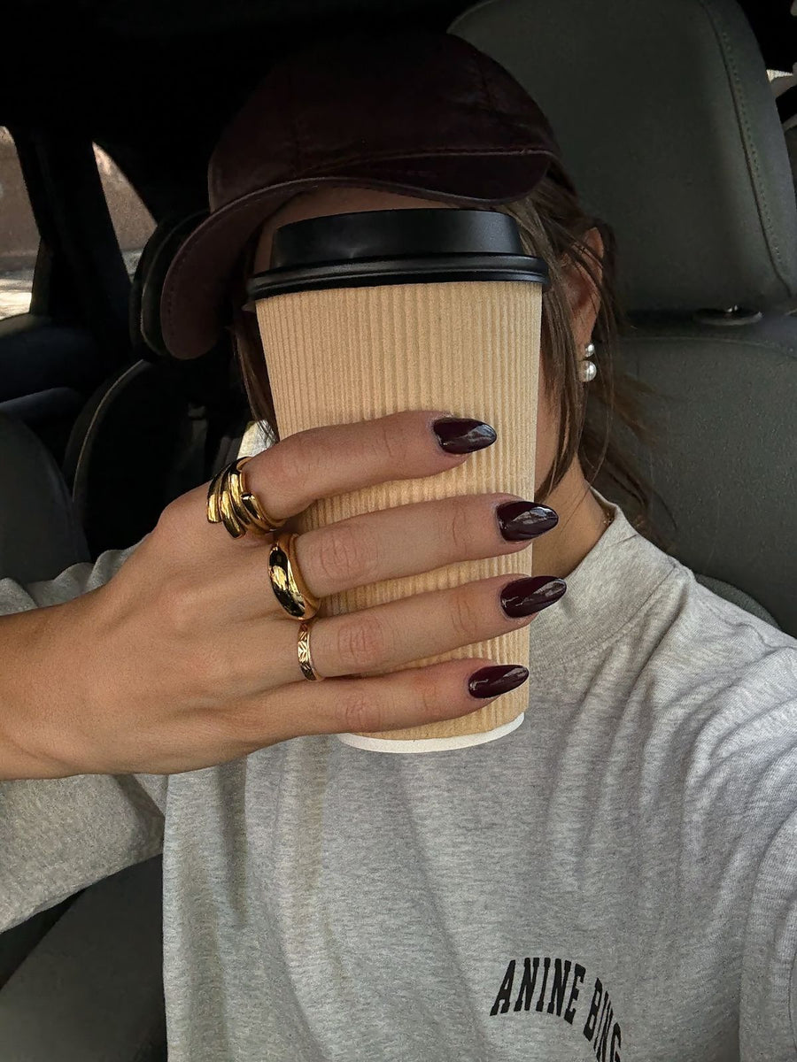 Cliente con anillos dorados gruesos de Vivante Madrid sujetando un café