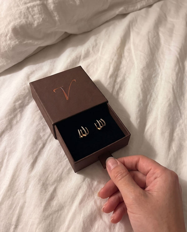 Foto de cliente abriendo la caja de regalo Vivante Madrid con los Pendientes Pantera en color oro